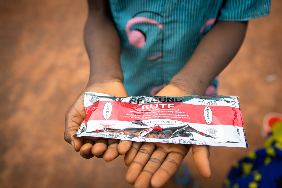 Marie*, 10, holds a package of Plumpy Nut, which is a peanut-based paste used in the treatment of severe acute malnutrition in children