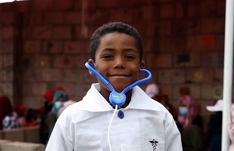 Osama* plays dress up at the social centre Taiz, Yemen.