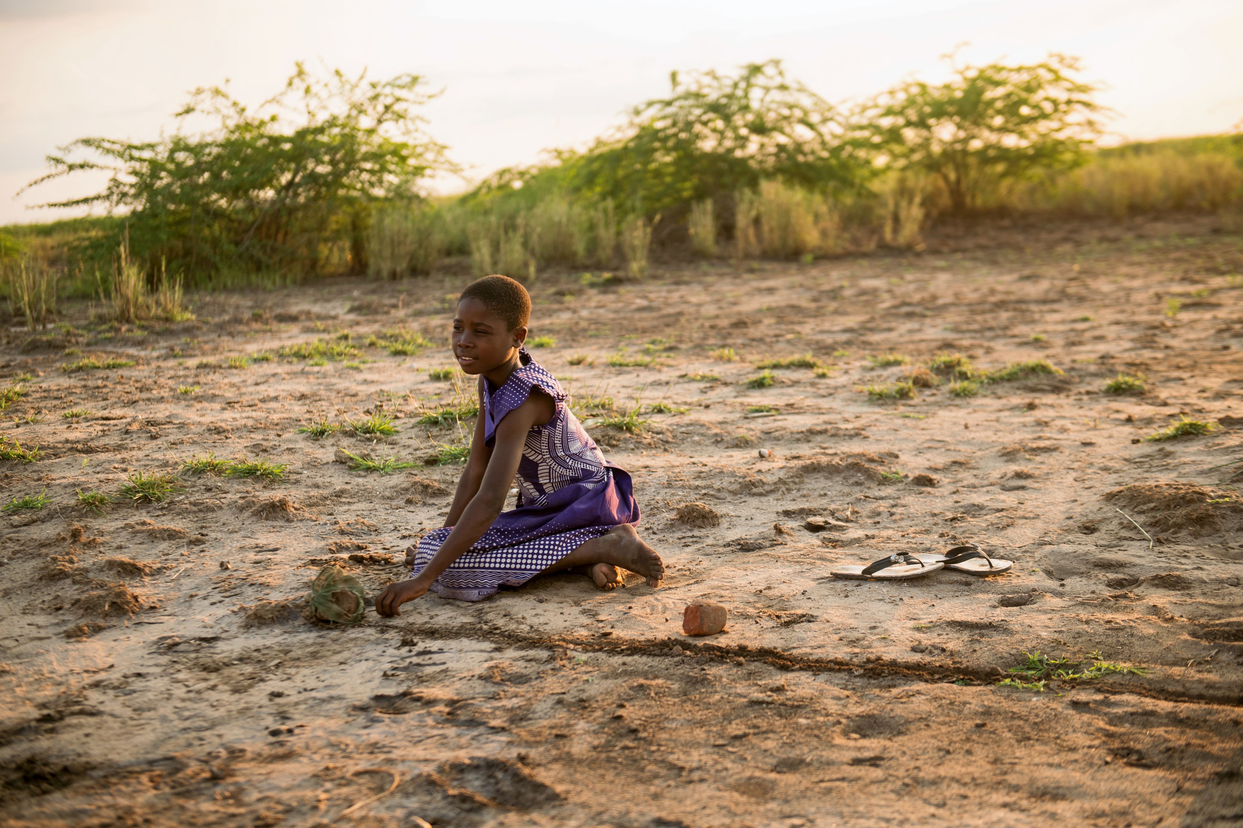 Sarah, 11, creating a map of where she used to live on dried up flood land, Malawi