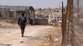 Kareem*, 16, walks to school in the West Bank with his schoolbag on his back.