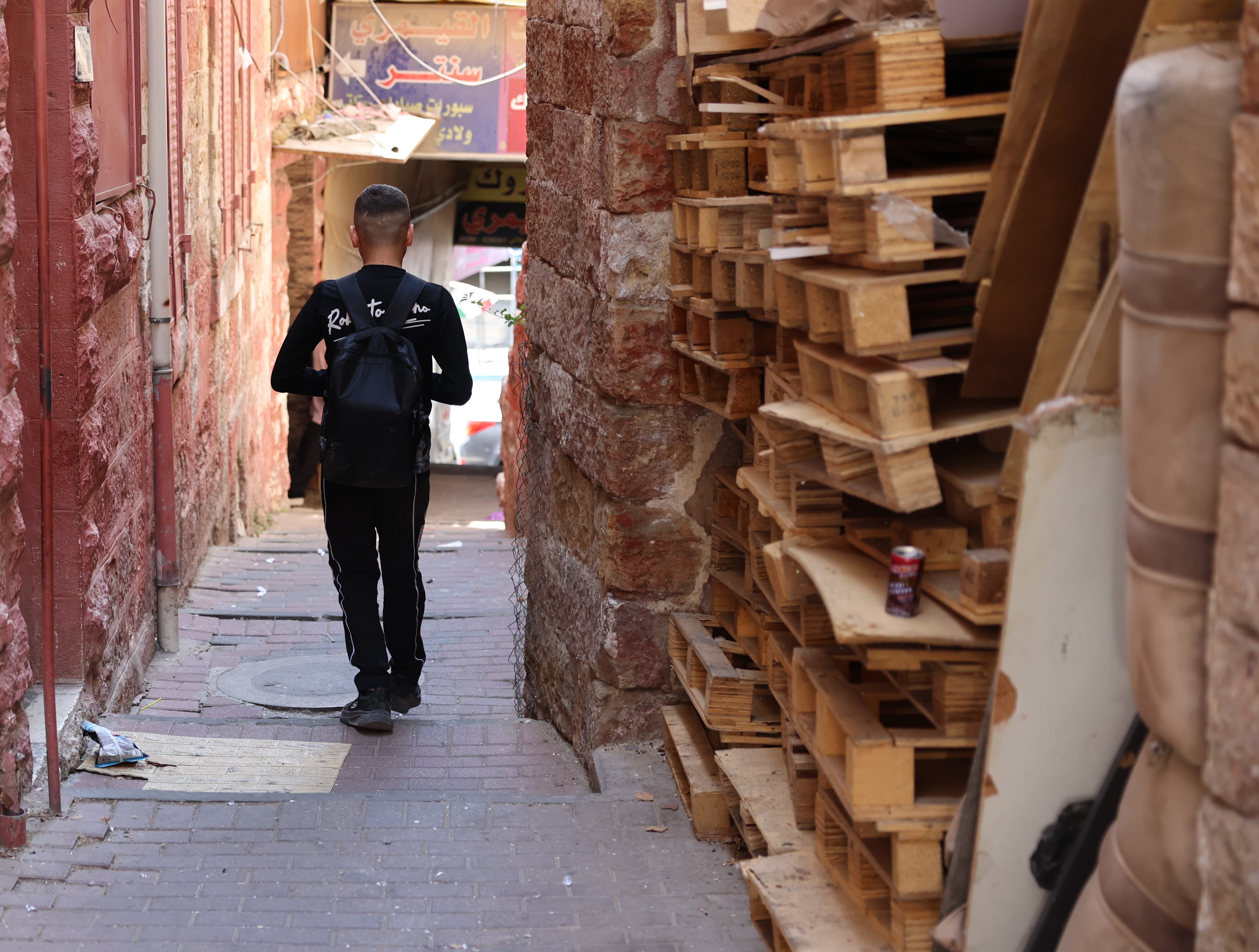 Yousef*, 14, walks to school in the West Bank with his school bag on his back.