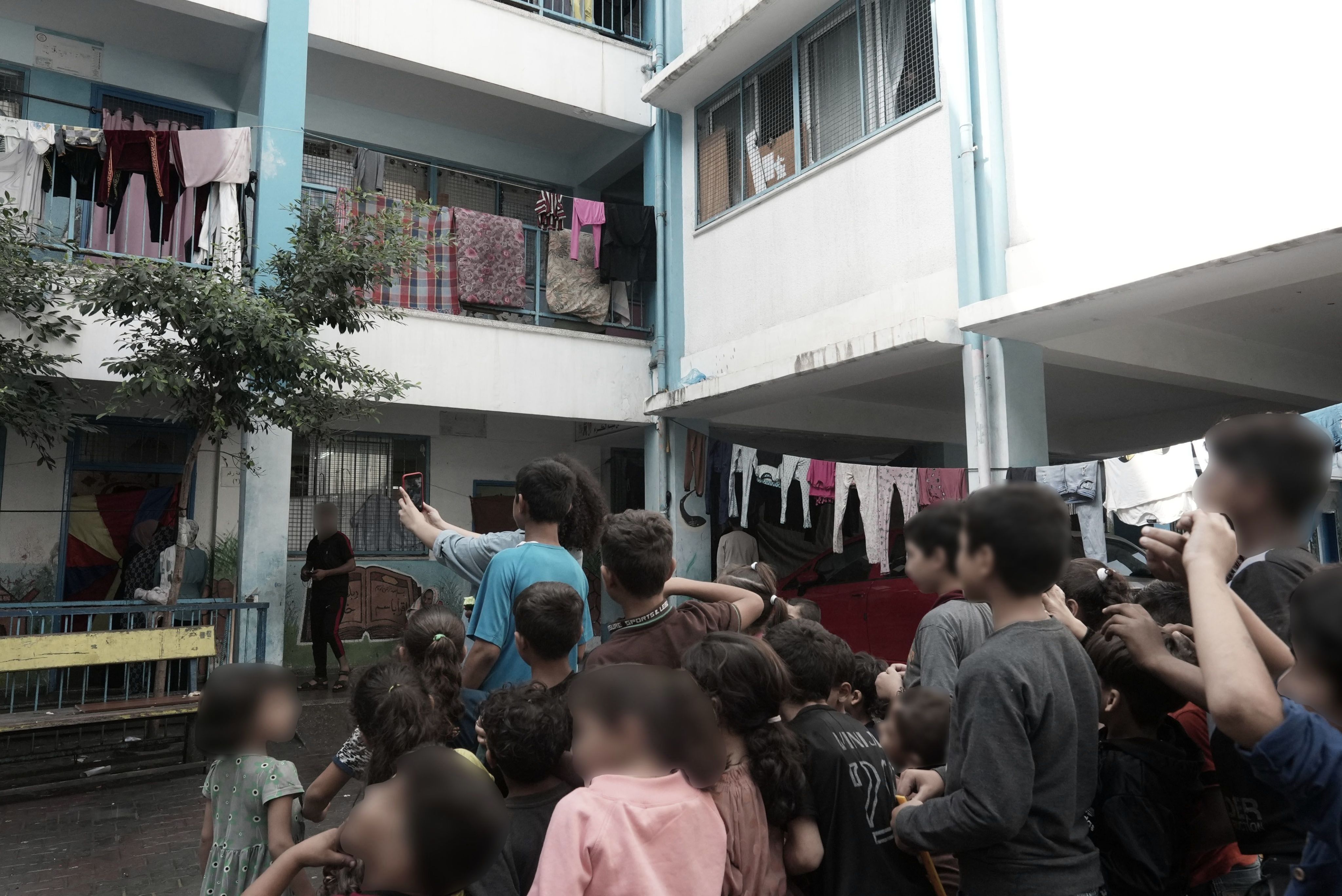 A group of children taking a photo at a shelter in Gaza.