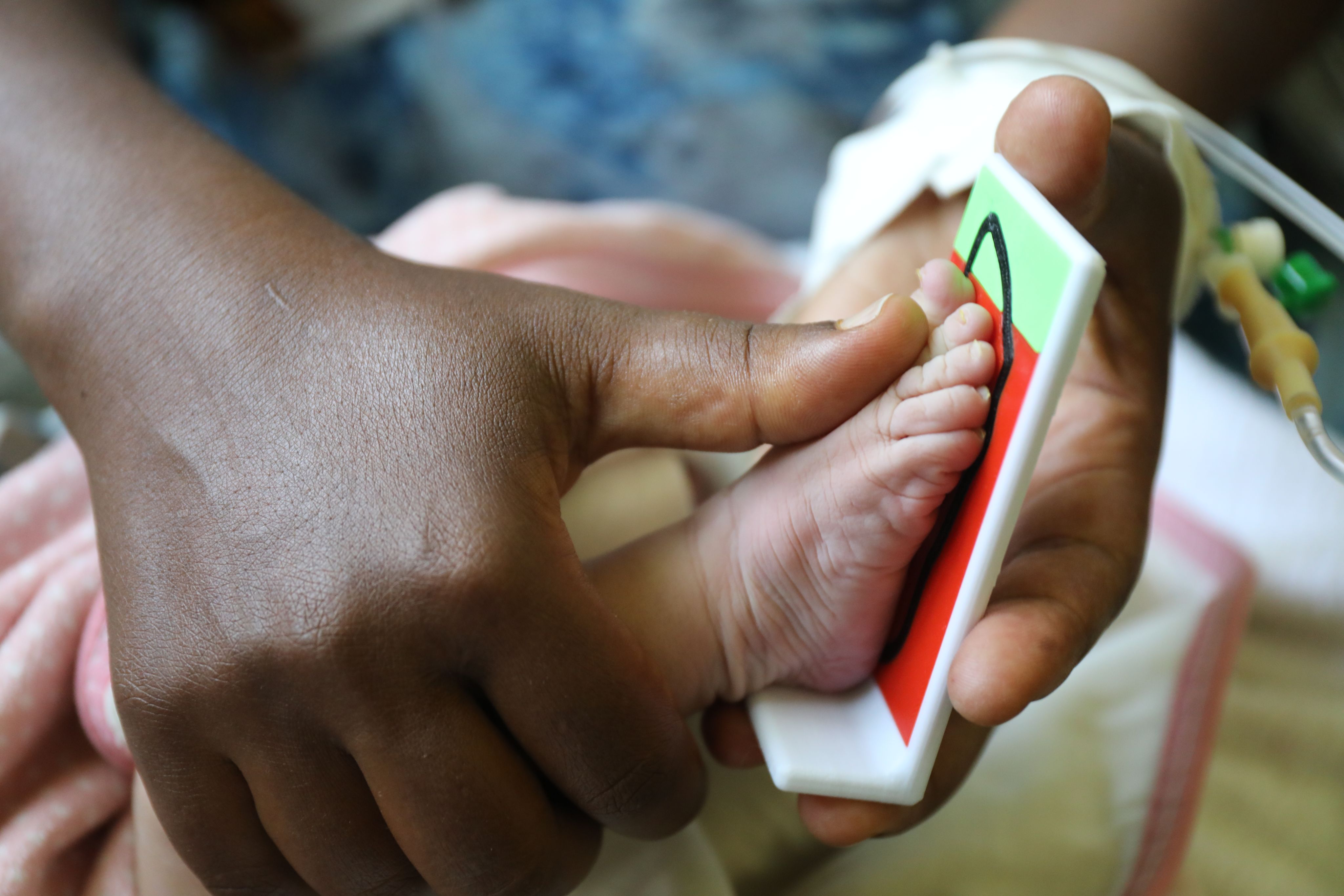  A mother measuring her newborn foot length at a hospital A mother measuring her newborn foot length at a hospital