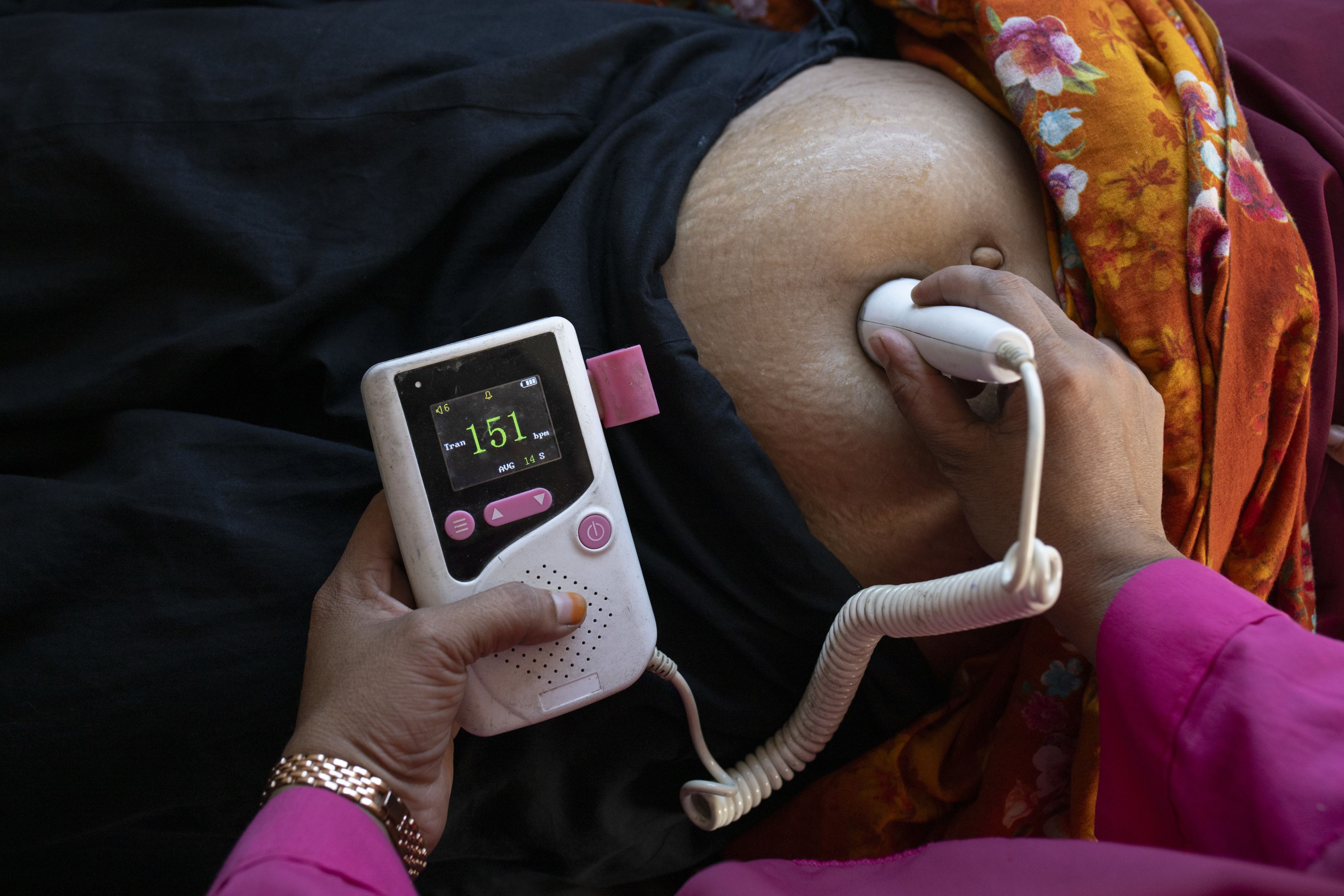 Nargis, a midwife at a satellite clinic run by Save the Children's Mamota project checks a mother and her baby in Gaibandha, Bangladesh.