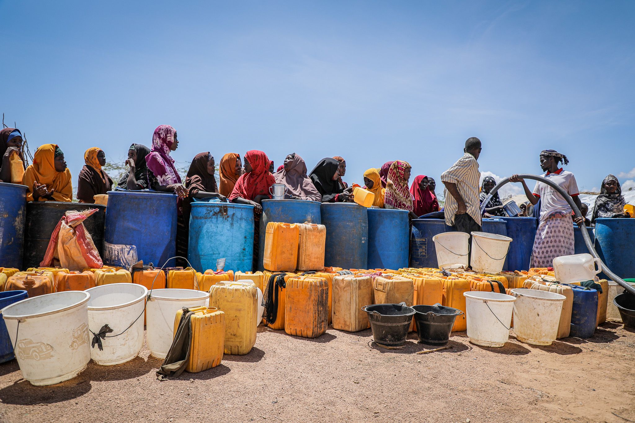 People queue for clean water provided by Save the Children after floods destroyed infrastructure in Southern Somalia. Image: Awale Koronto/ Save the Children