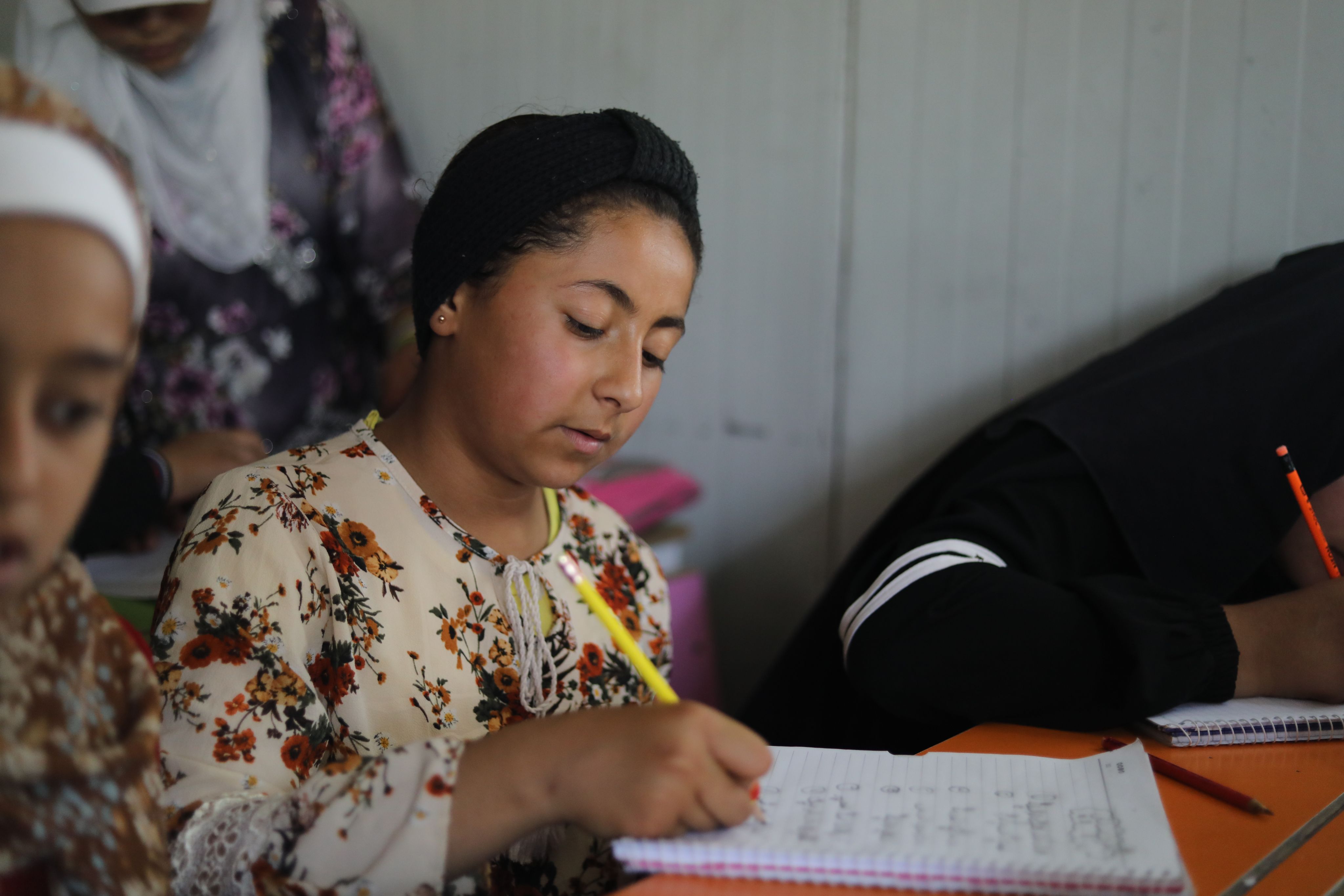 Maya, 12, writes in her book during a lesson at school, Syria.