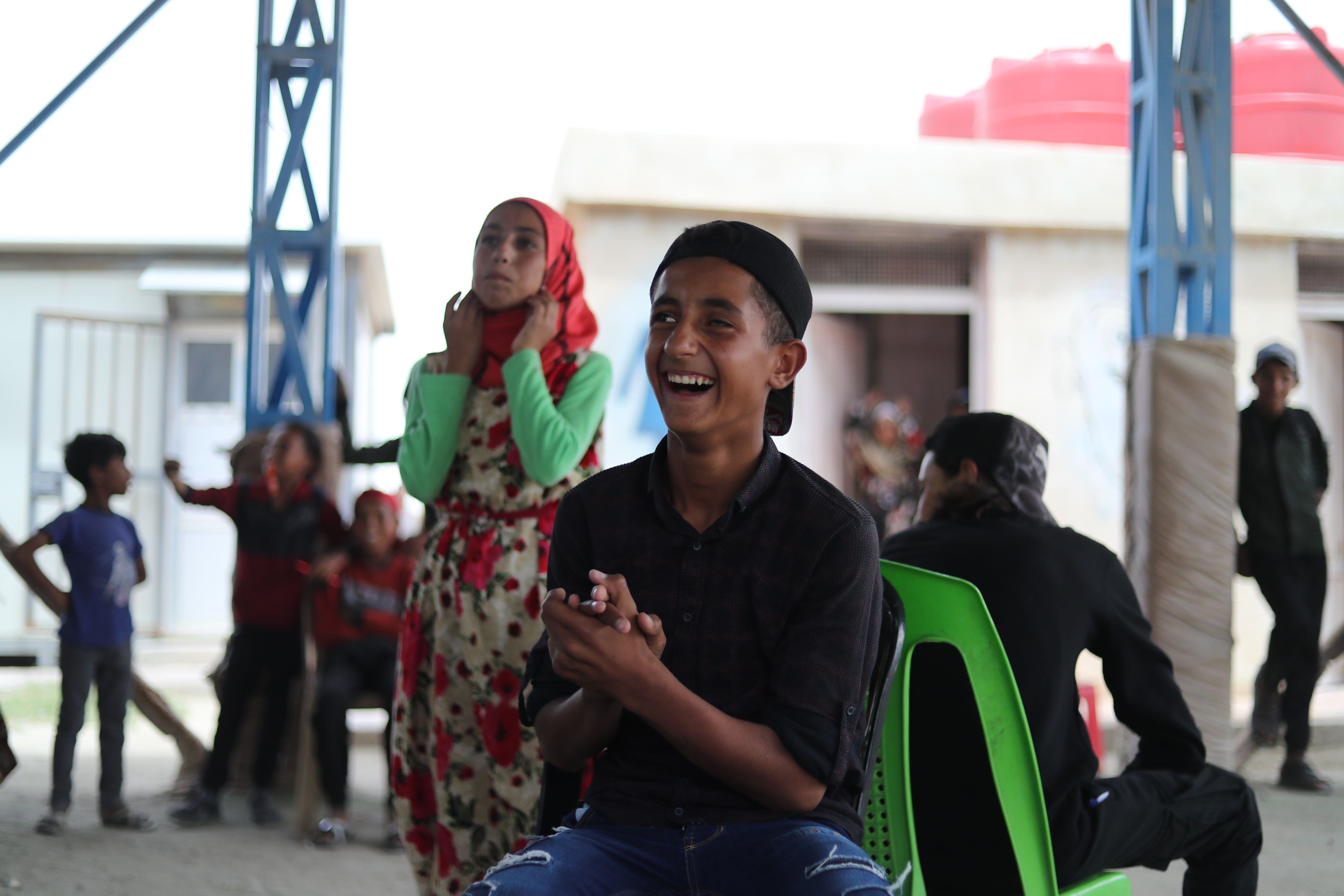 Danyal*, 13, laughing with friends during a game at the learning centre.