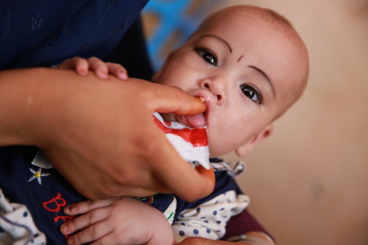 Nahida* (8 months), tasting Plumpy'Nut provided by a mobile health team of Save the Children.