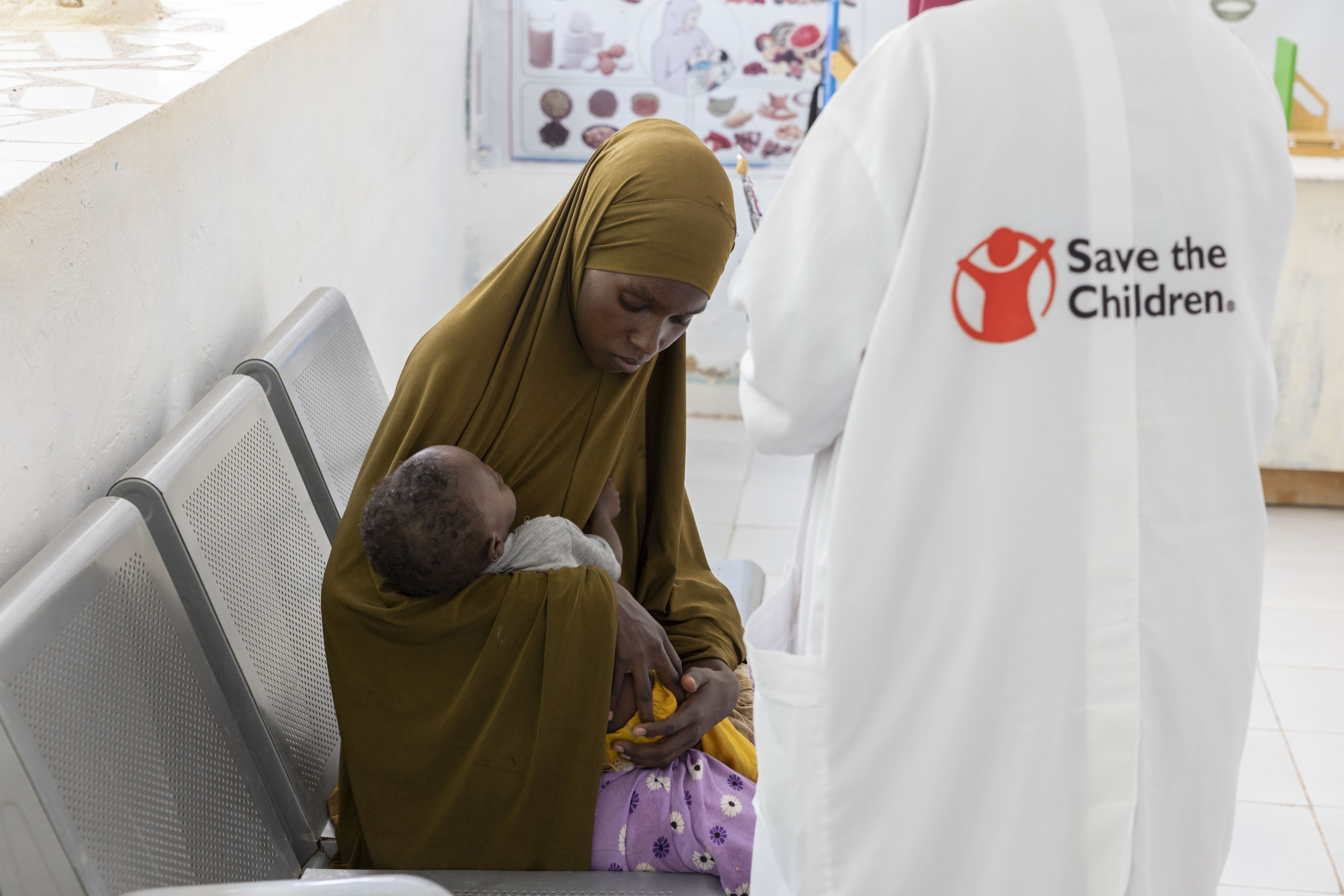 Idil* with her son Dalmar*, 15 months old, as he's screened by a Save the Children nurse. 