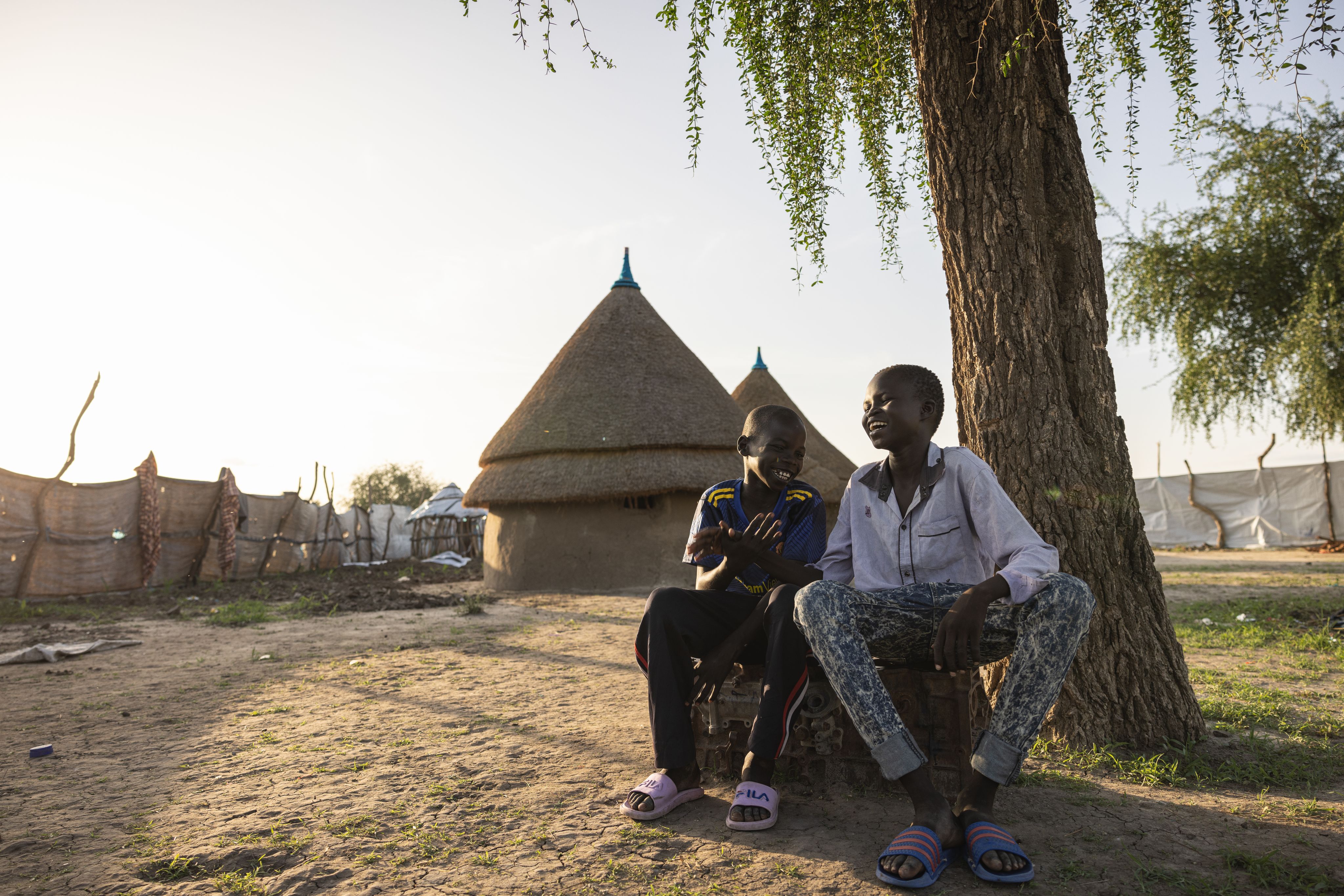 Jok*, 12, chatting with his best friend Kuol* (10) outside his home in Akobo West, South Sudan