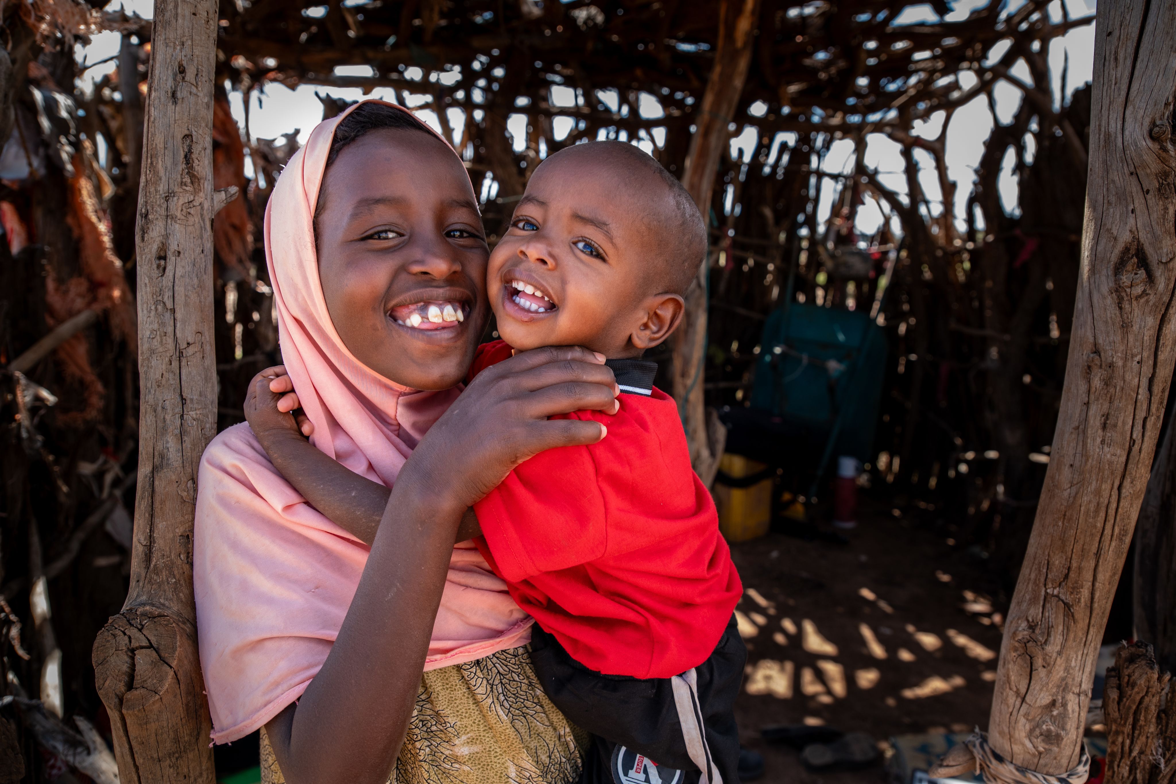 10-year-old Faduma* holds and cuddles her little brother Abdi*.