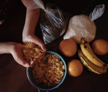 Maria Elena, 12, at home with the food she receives from Save the Children's school meals programme, in Guatemala.