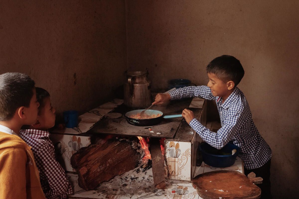 Tomás, nine, making eggs with tomatoes at his home in Quiche district, Guatemala