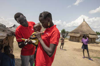 Community Nutrition Worker Nyawany, 27, visits one-year-old Machar*, who is receiving treatment for severe acute malnutrition in South Sudan.