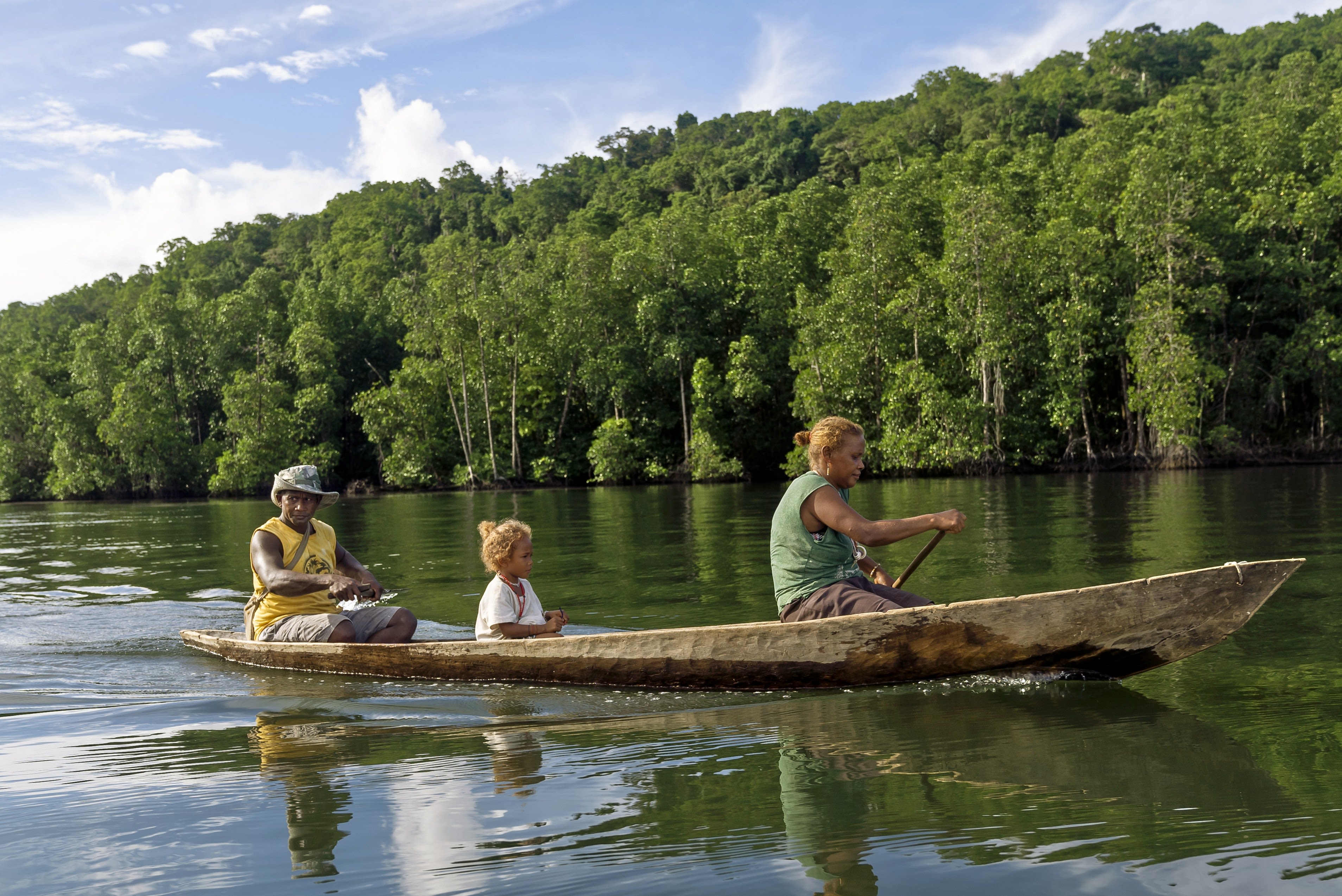 Alison, 43, her husband David, 36, and daughter Lucy, four, travelling by canoe to the bee keeping training in Malaita Province, the Solomon. 