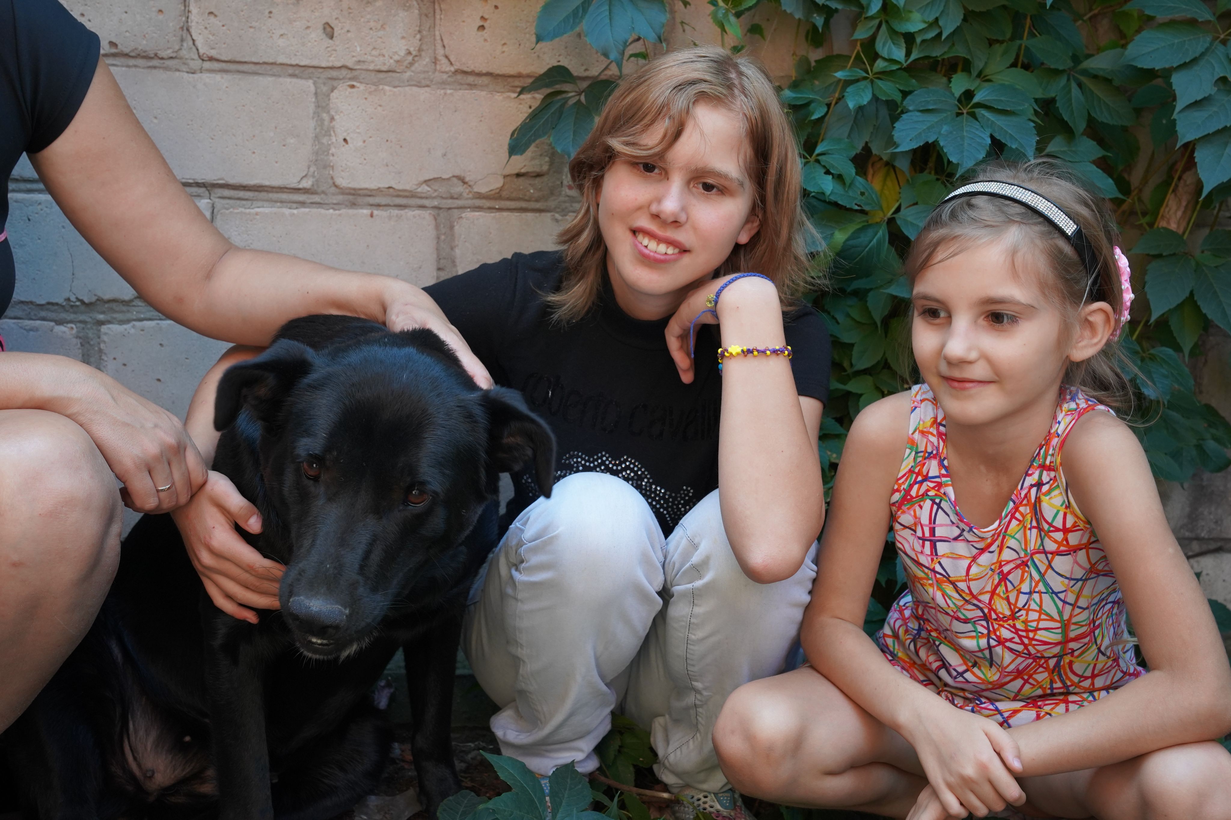 Olha*, 17 and Liya*, 7 with their dog Sherry who fled war with them in Ukraine