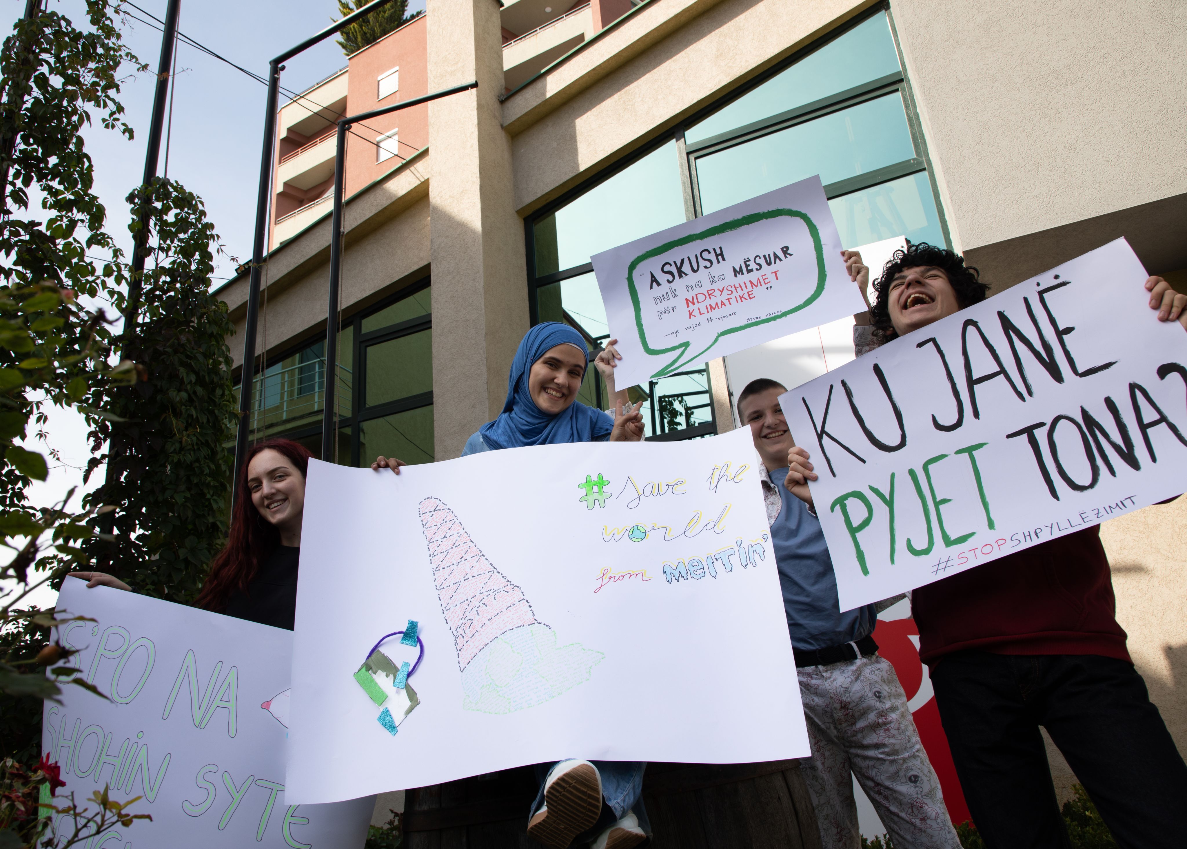 Olt, 16, Loris, Festina and Sara hold up their banners they have made for the climate march they organised in Prishtina, Kosovo