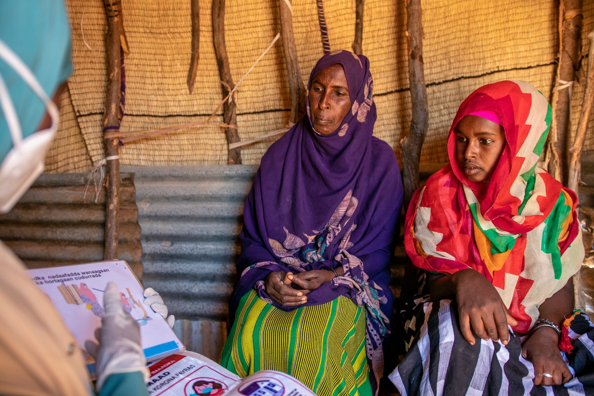 Muna, Family Health Worker, giving Ayan advice on breastfeeding & basic hygiene
