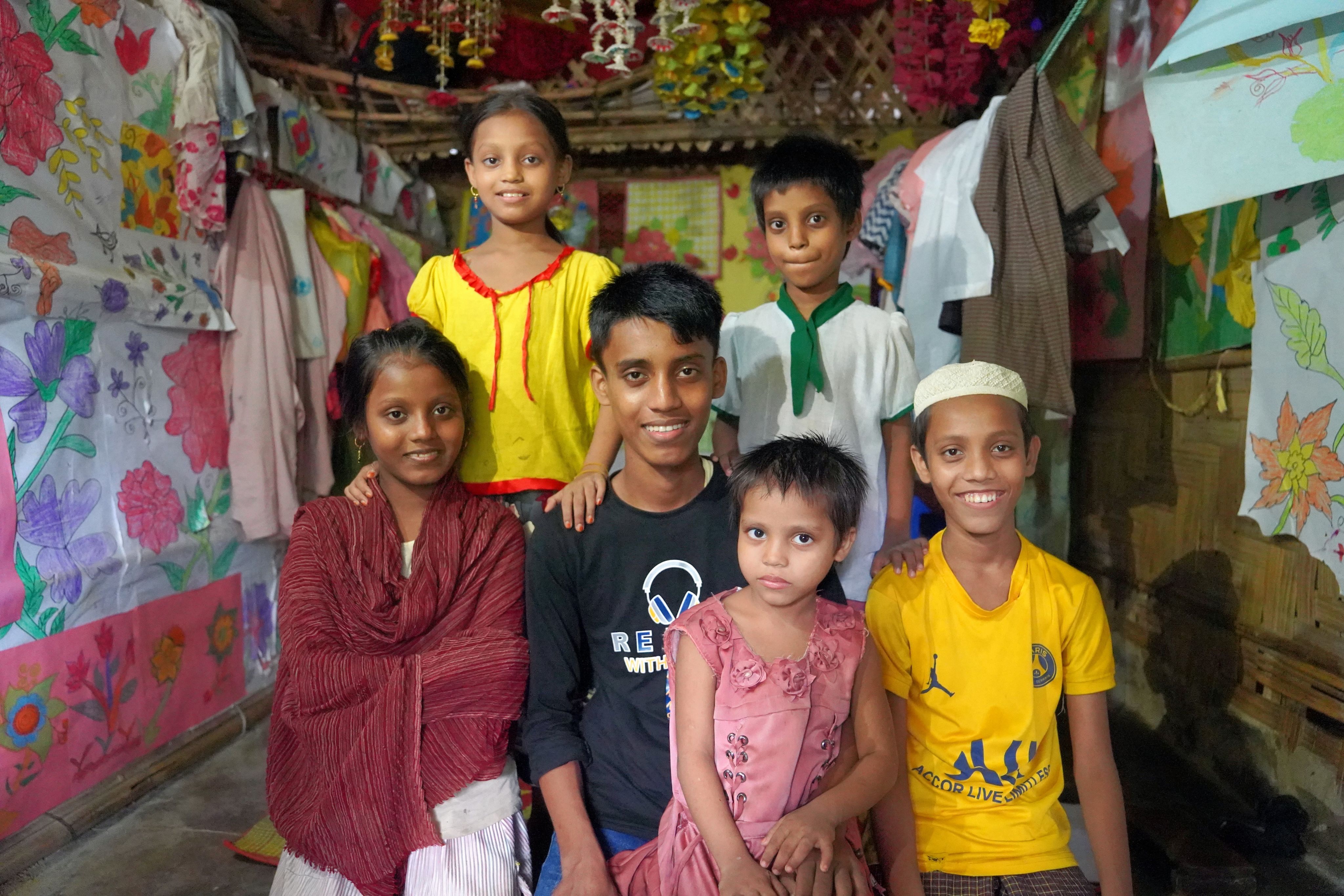 Ayaz*, 15, Fahim*, 12, Anisa*, 11, Salema*, 8, Maleka*, 6, & Jesmin*, 4, posing for a photo in Cox's Bazar, Bangladesh. 