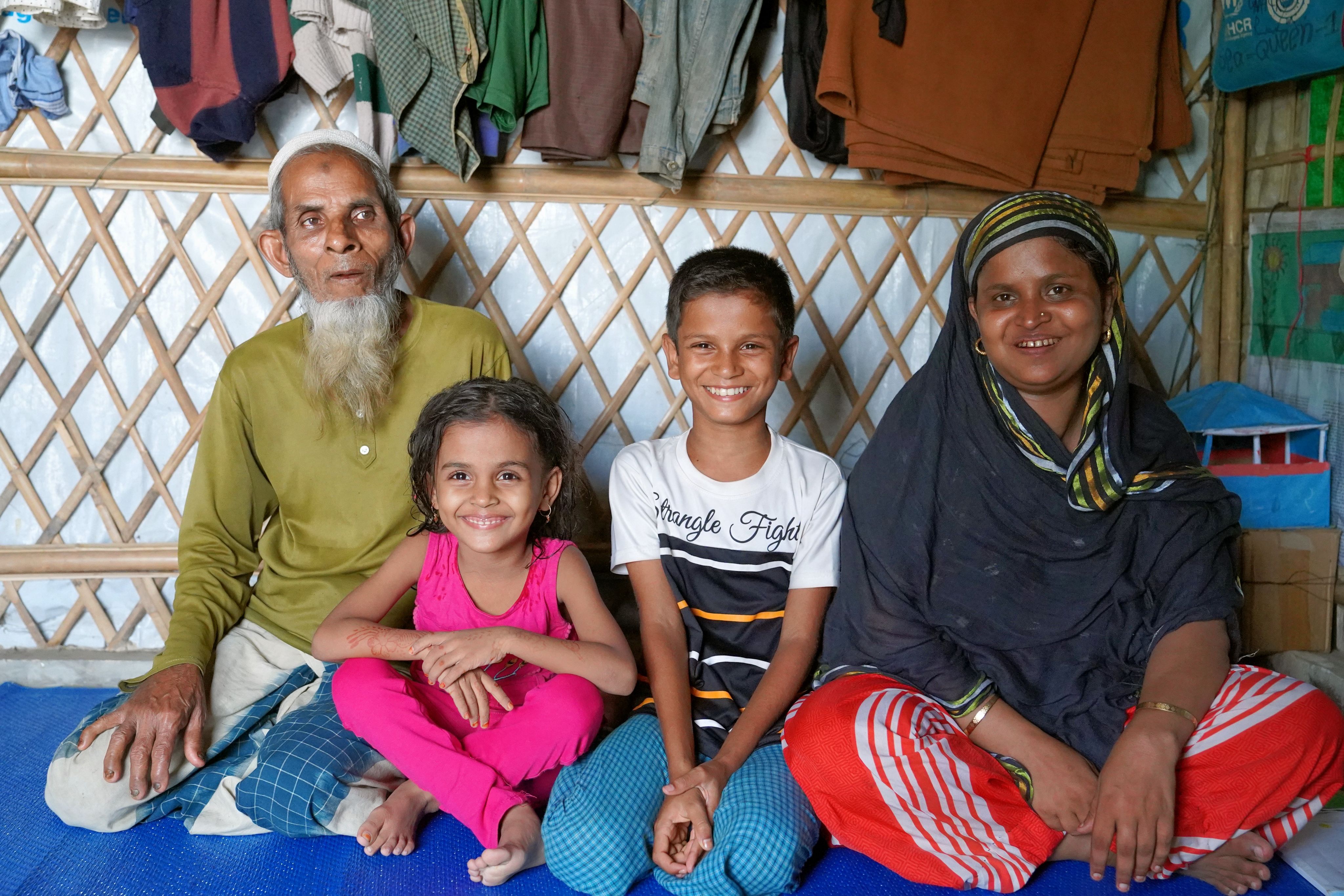 Antora*, 5, Zia*, 12, Meherun Nesa*, 40, & Anasullah*, 63, pose for a family photo in their house in Cox's Bazar, Bangladesh.