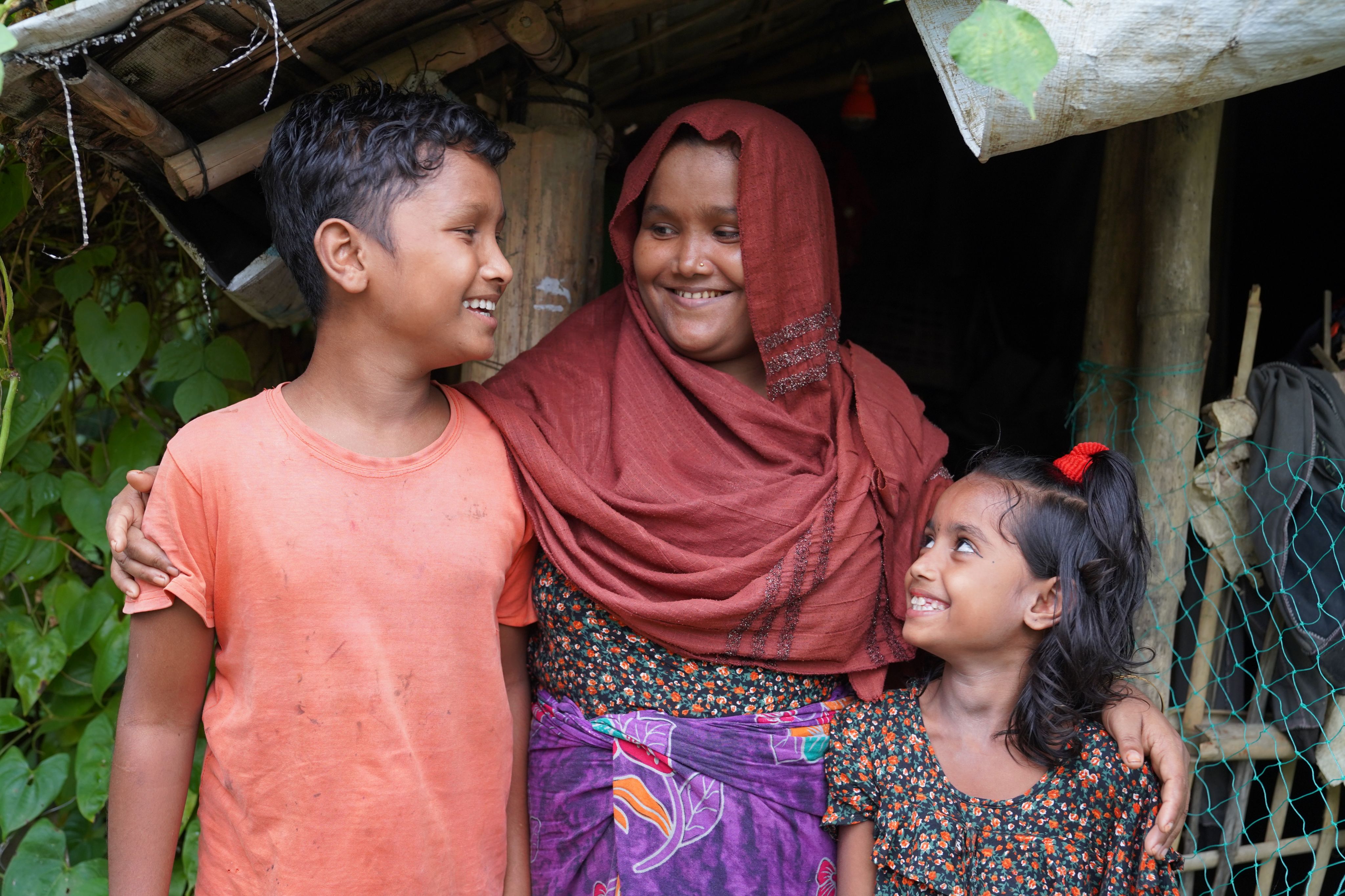 From Left to Right: Rakib* (12), Mahbuba* (31), and Sultana* (7), at their camp.