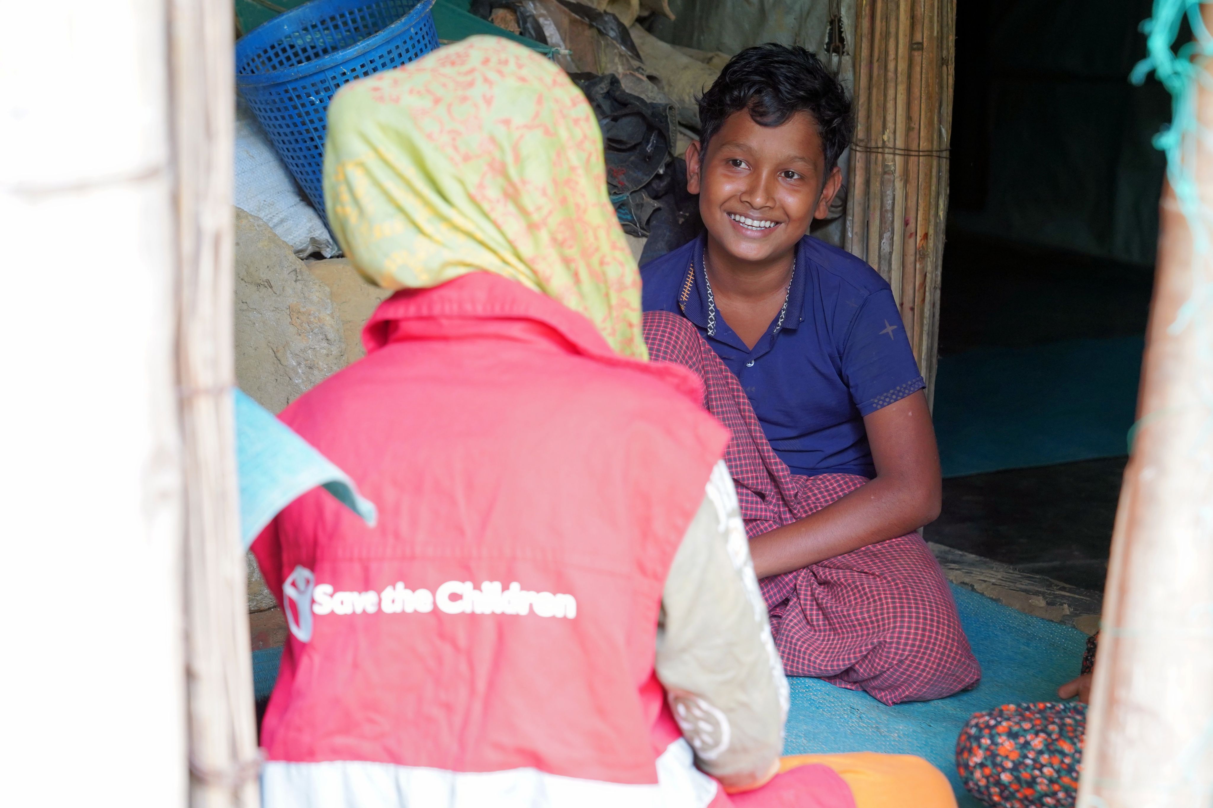 Rakib*, 12, speaks to a Save the Children staff members in Cox's Bazar, Bangladesh