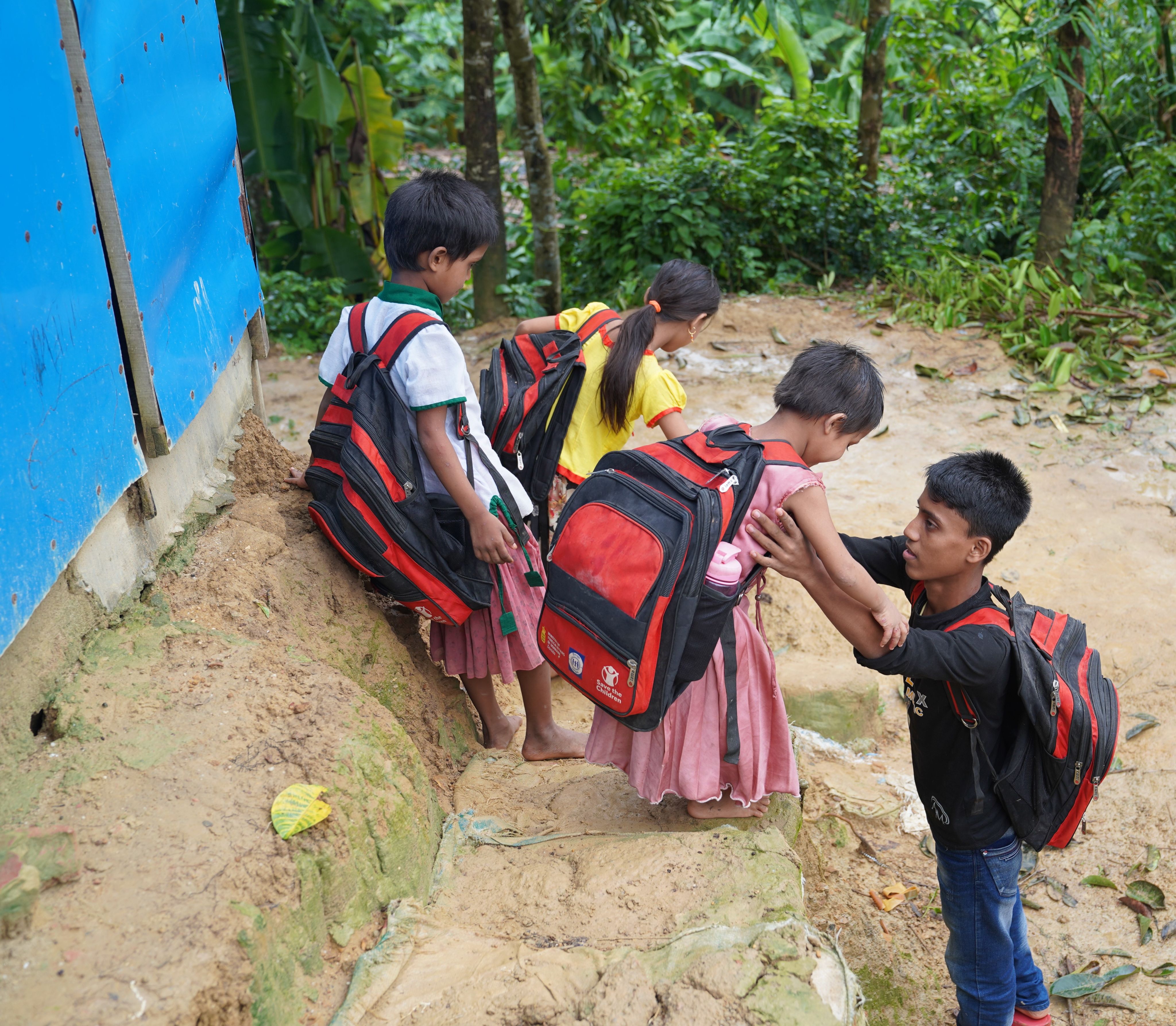 Ayaz*, 15, and his younger siblings en route to a Save the Children supported Learning Centre in Cox's Bazar, Bangladesh
