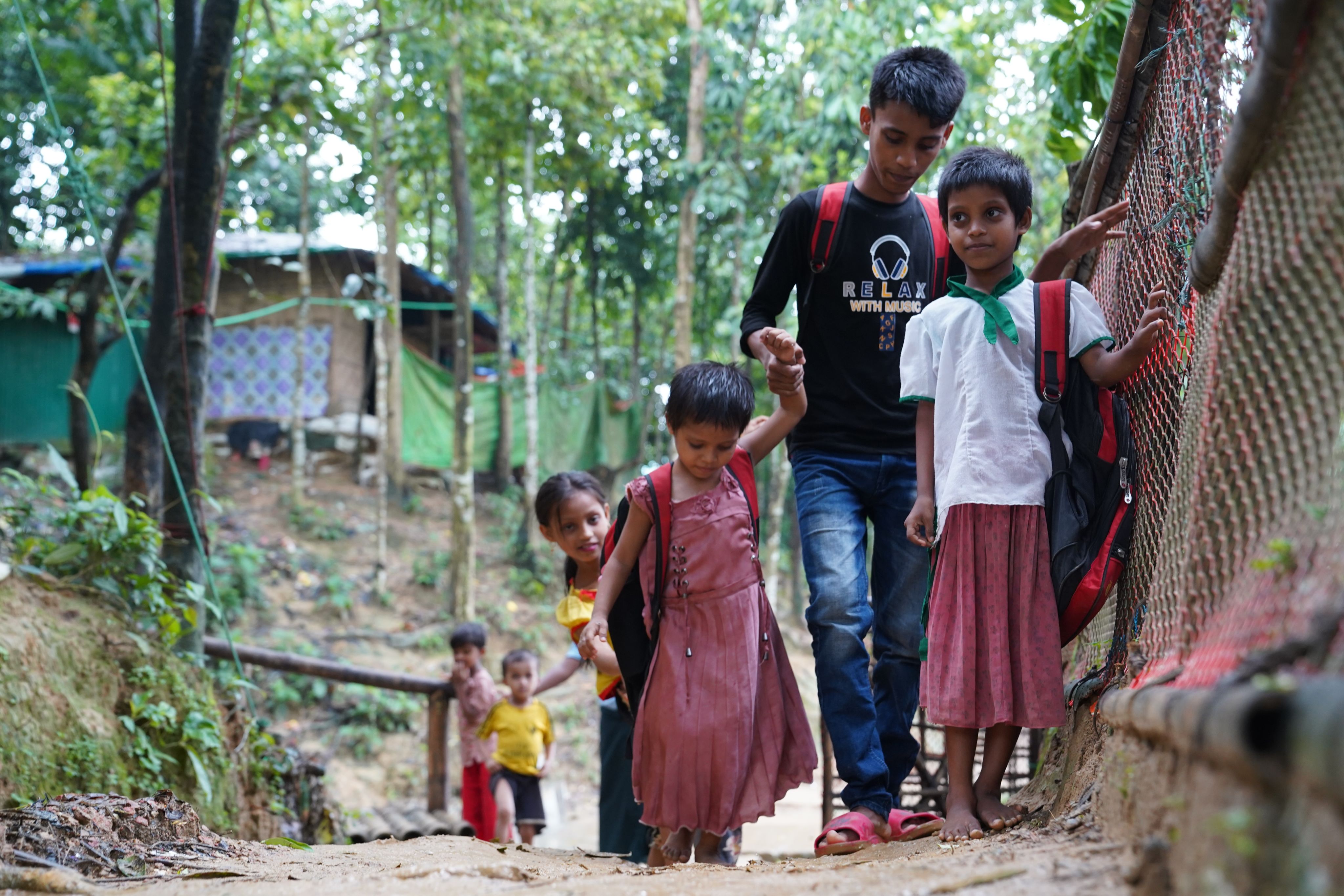 Ayaz*, 15, and his younger siblings walk to a Save the Children supported Learning Centre in Cox's Bazar, Bangladesh