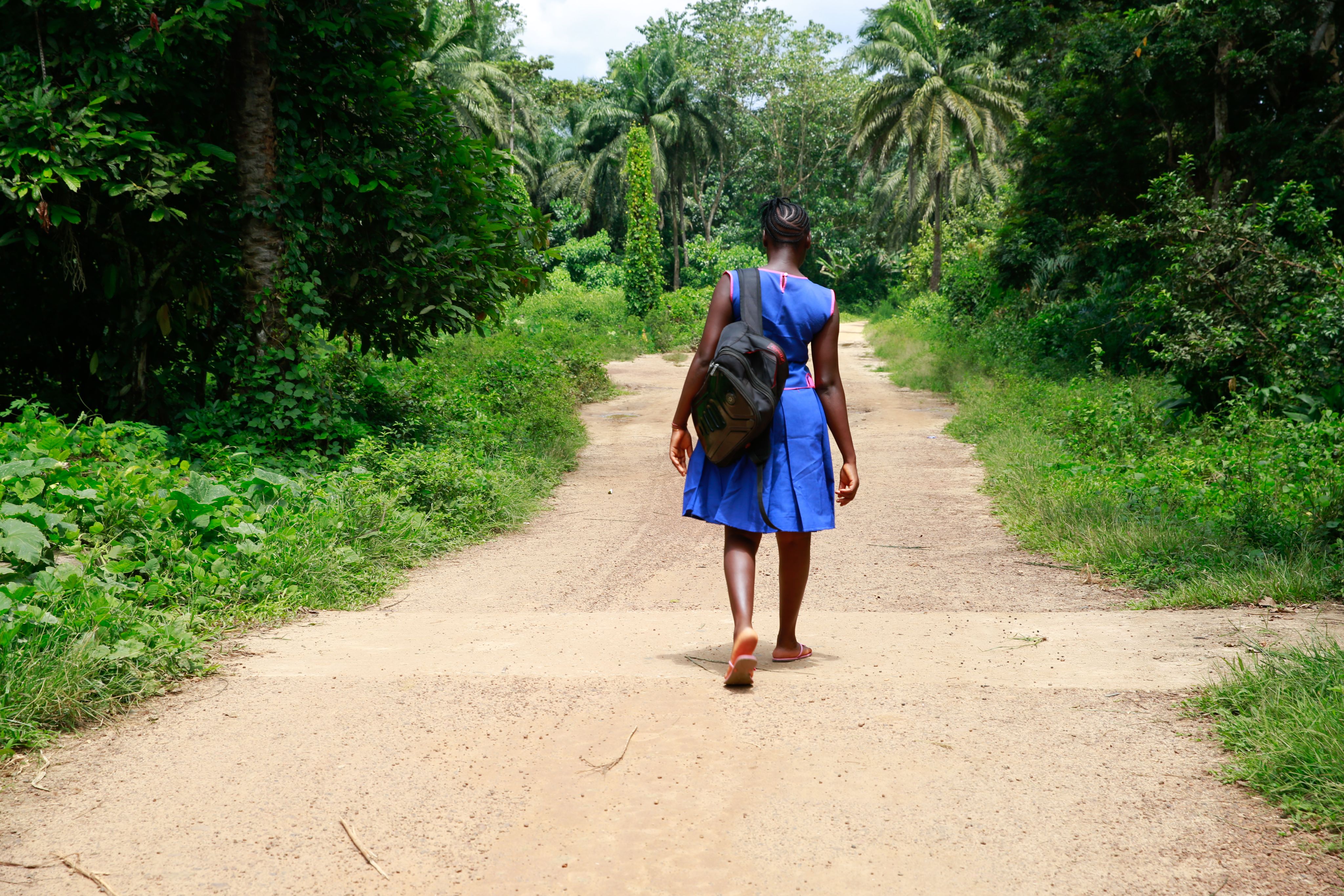 Kpemeh*, 18, walks to school in Kailahun, Sierra Leone