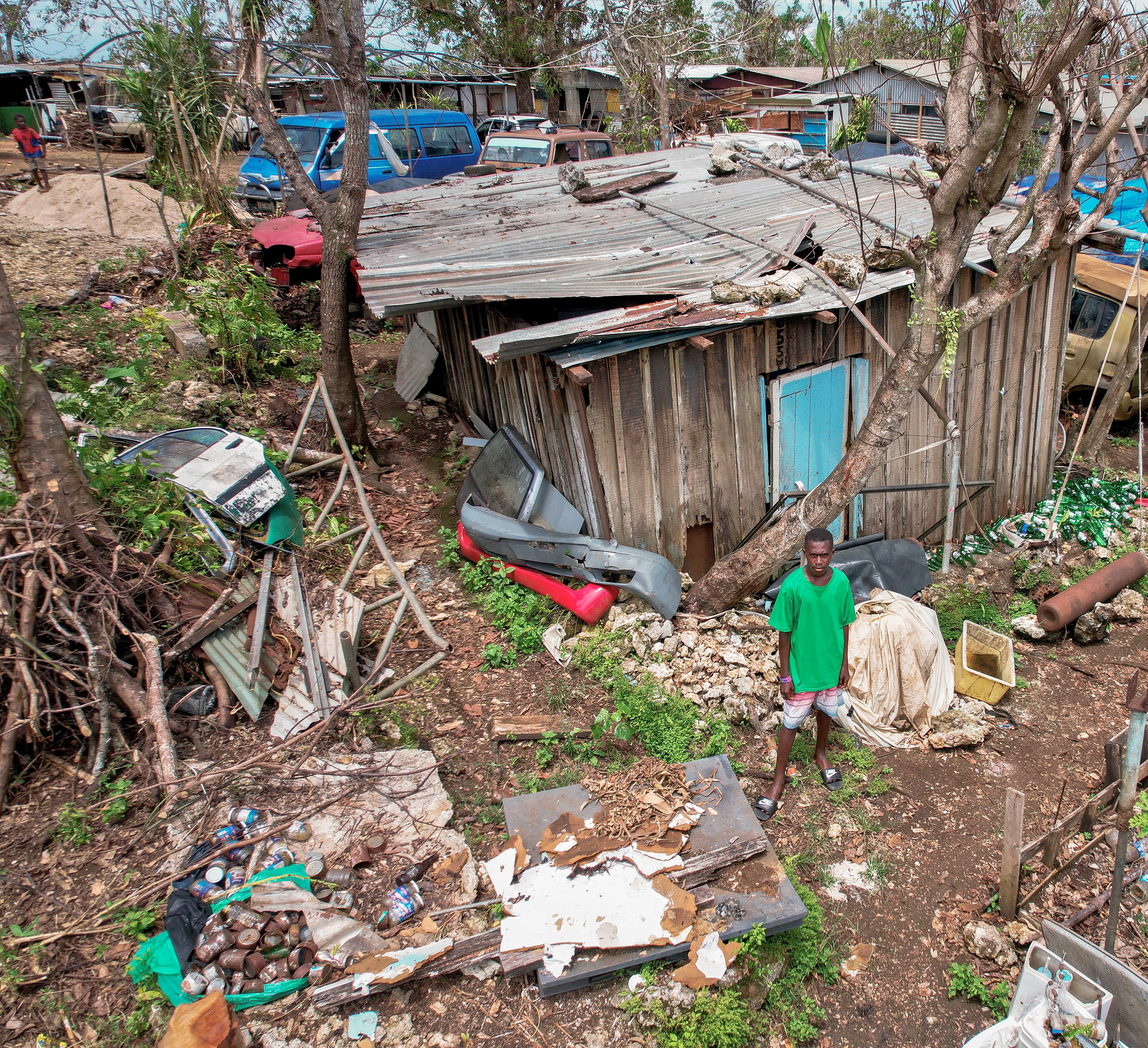 A drone shot of Lee Roy, 15, standing in front of his family's house after it was destroyed by cyclones in Vanuatu