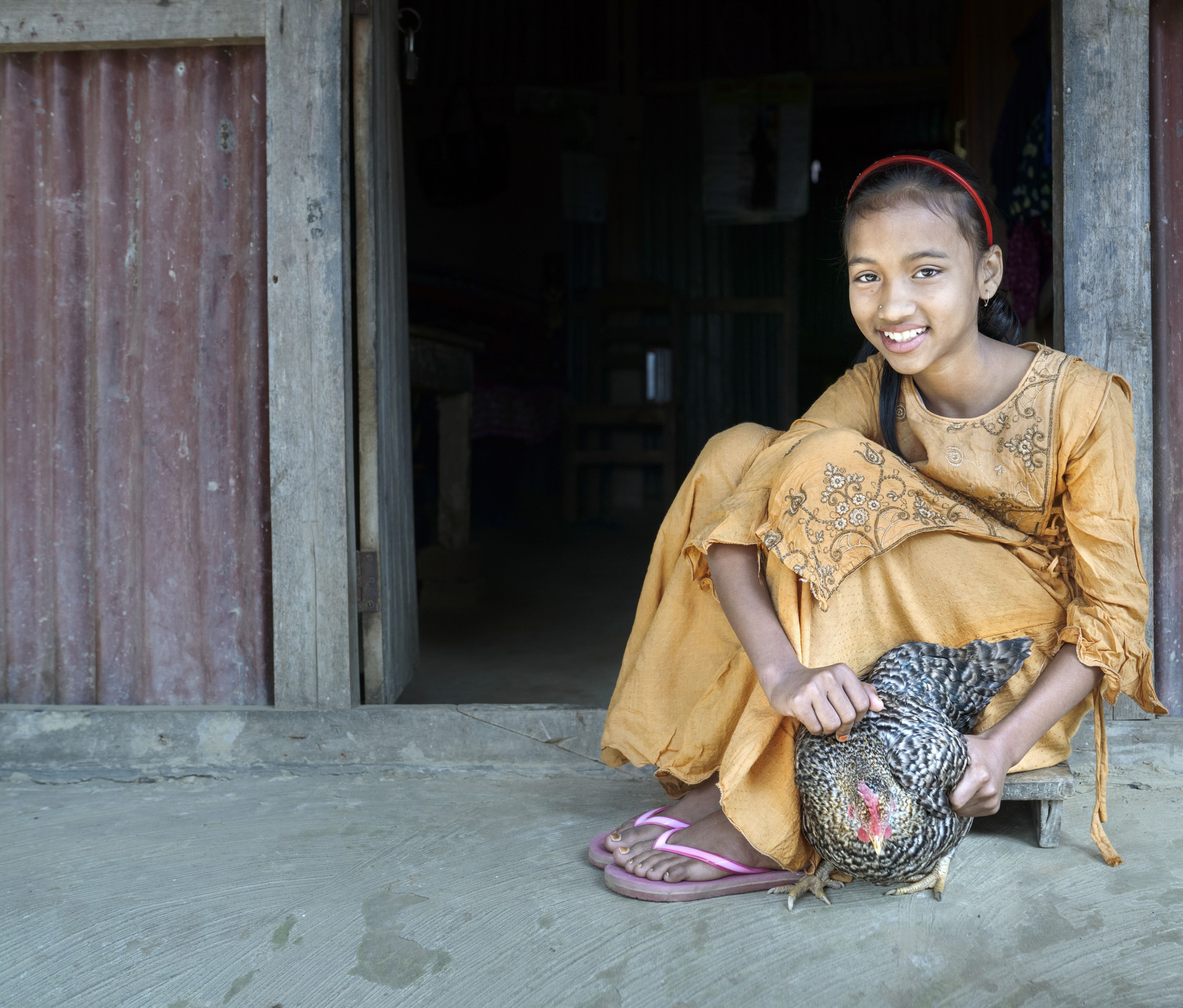 Afsa, 9, holds one of her favourite chickens 'chickoo' at home in Sylhet, Bangladesh