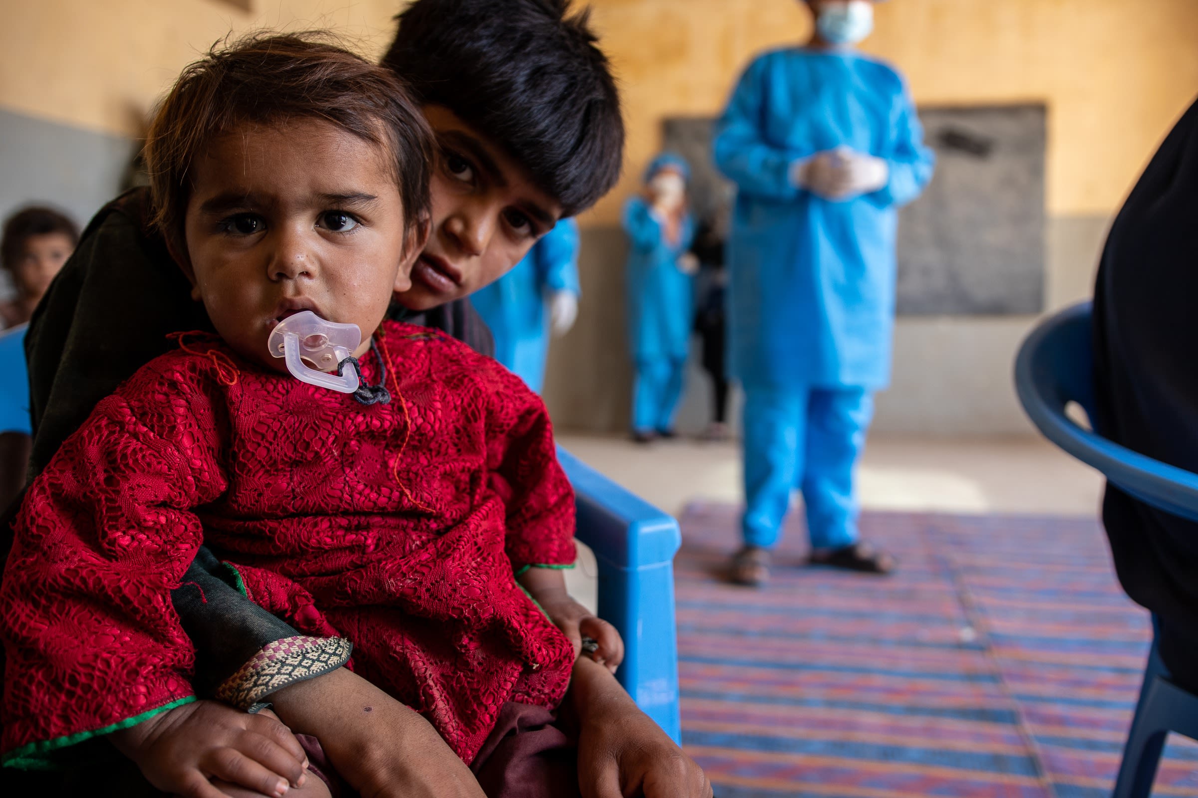 Temor* (12) holds his brother Sultan* (2) at a Save the Children mobile clinic in Afghanistan