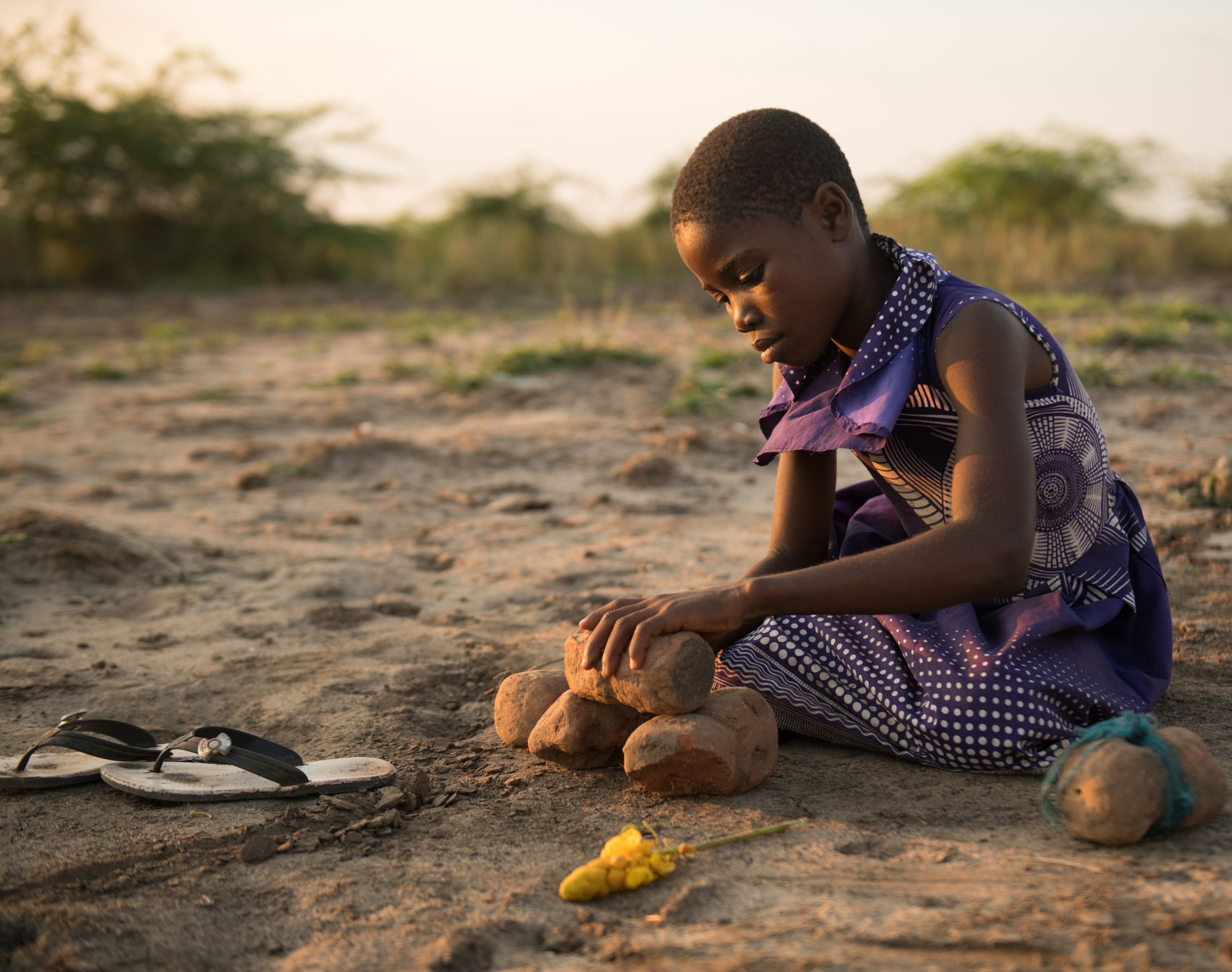 Sarah, 11, using bricks to represent her house that was destroyed during the flood, Malawi.