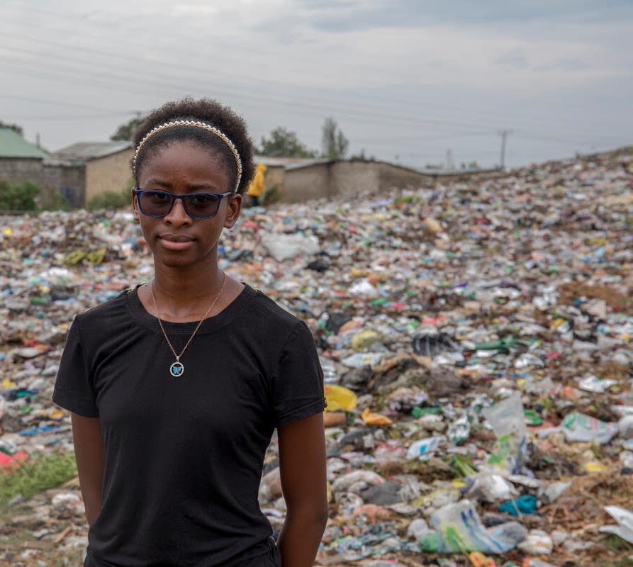 16-year-old Justina, a child climate activist, poses for the camera at the dumpsite in her community in Zambia