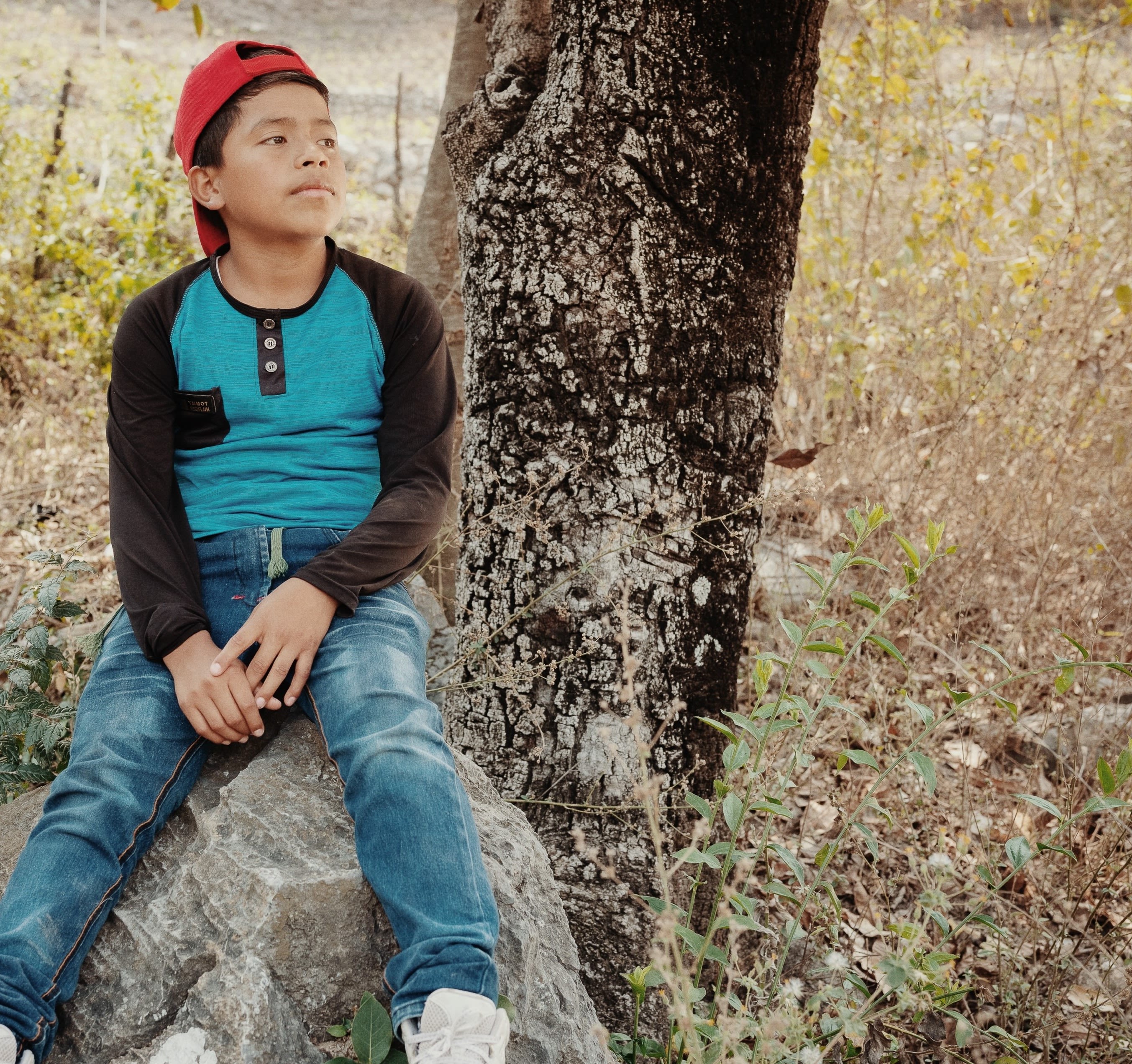 Walmar, 11, sits on a rock outside his home in the Dry Corridor region of Guatemala. 