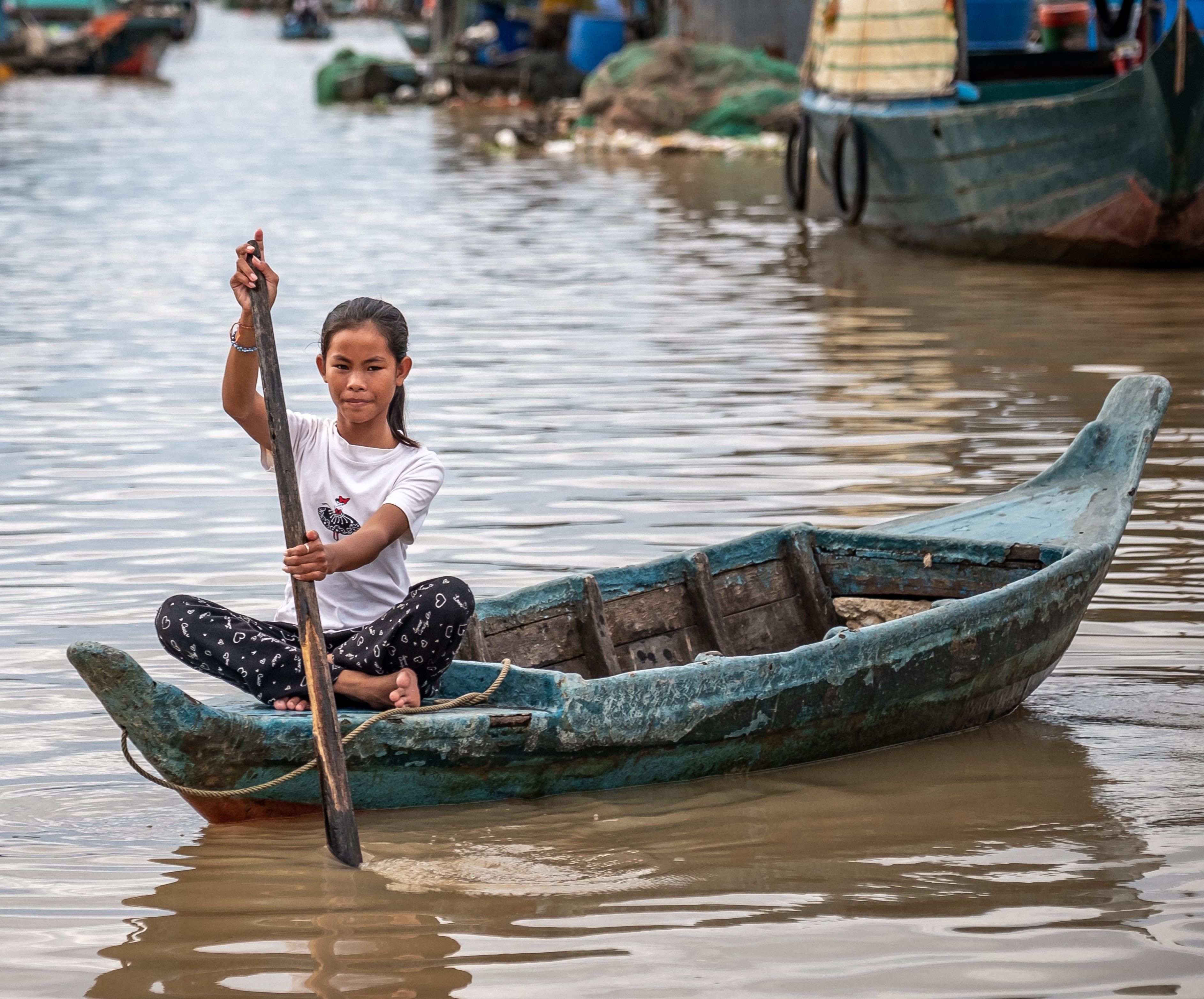 Ratana, 12, paddling a boat on Tonle Sap Lake, Cambodia.