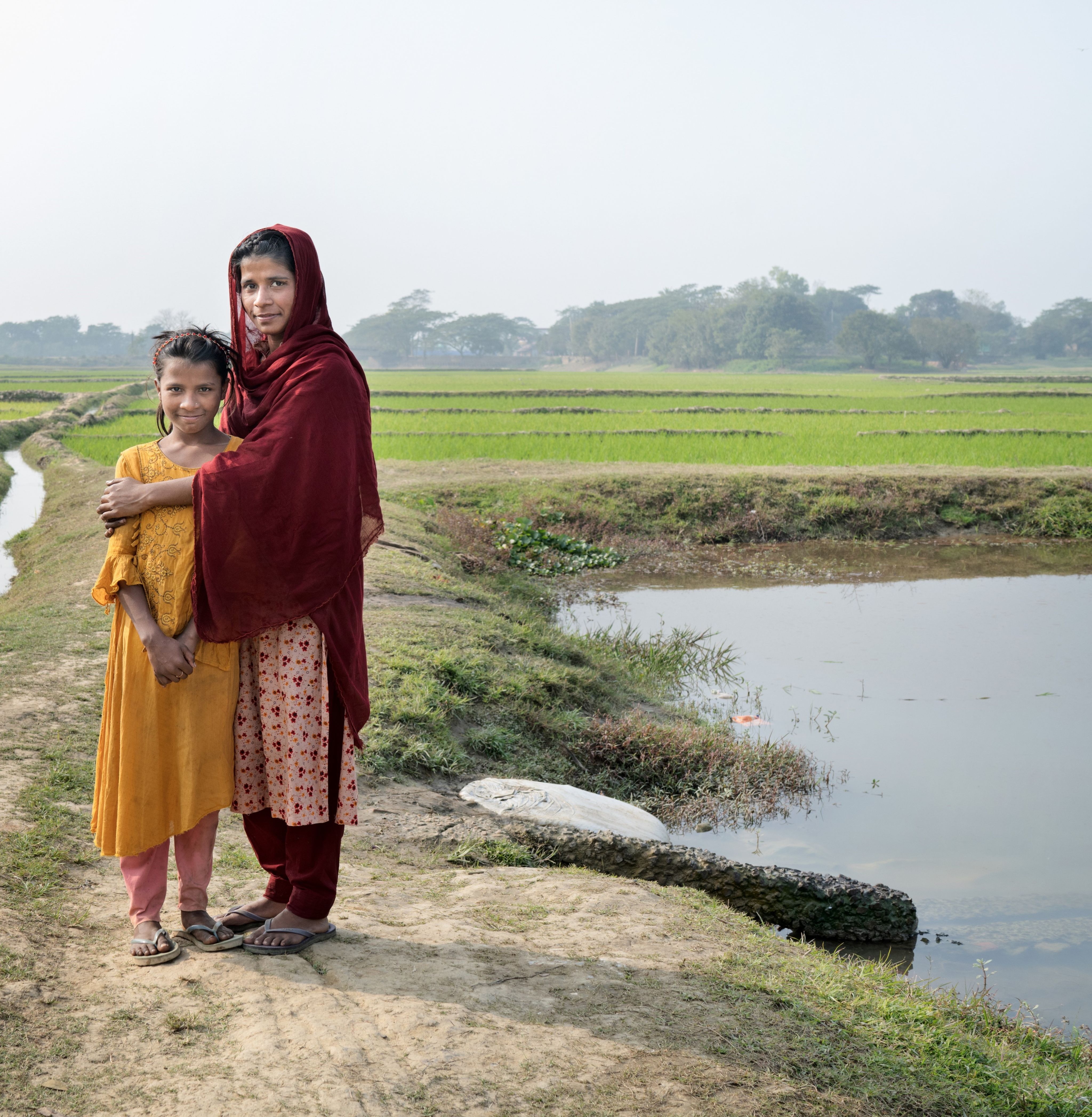 Portrait of Munni, 18, and her sister Tanni, 12, by Munni's fish pond at their home in Sylhet, Bangladesh